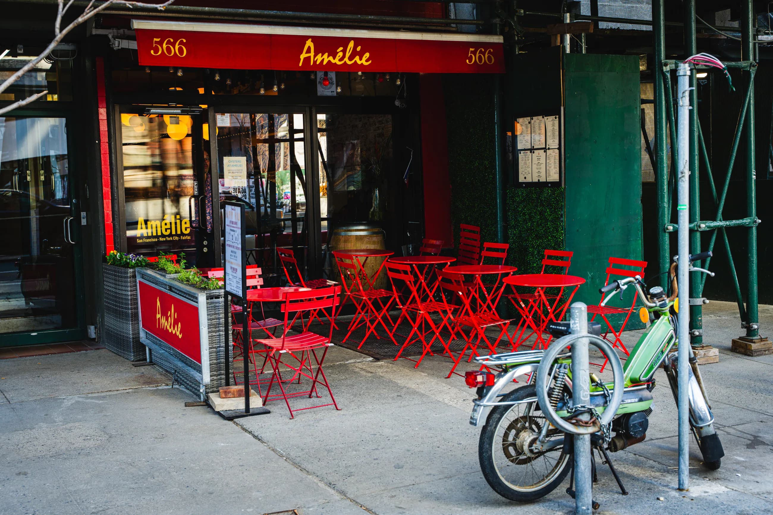 The red awning and red bistro chairs outside Amélie at 566 Amsterdam Avenue