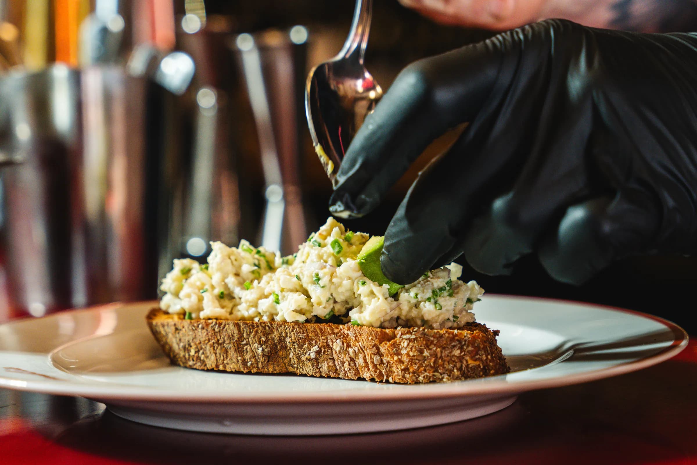 A crab tartine on toasted sourdough being finished with a spoon at Amélie West Village